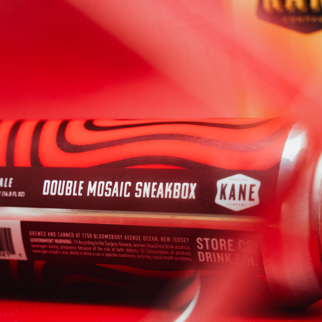 Cans of Kane Double Mosaic Sneakbox Pale Ale on a red background
