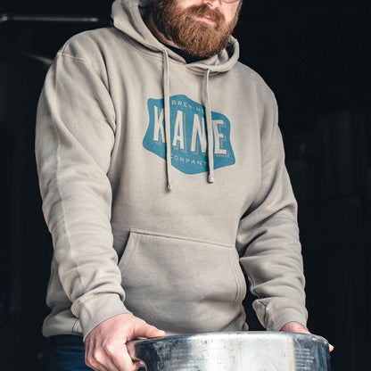 Person wearing a Kane hoodie with a logo, holding a keg.